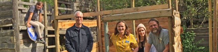 Vier Personen stehen vor einer selbst gebauten Hütte im Biberbau in Wiesbaden.